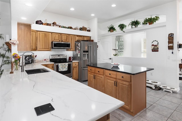 kitchen with a center island, light stone countertops, sink, and stainless steel appliances