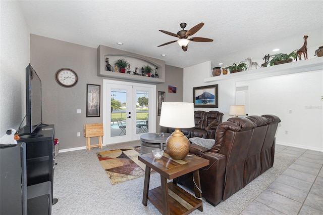 living room with a textured ceiling, tile patterned flooring, ceiling fan, and french doors