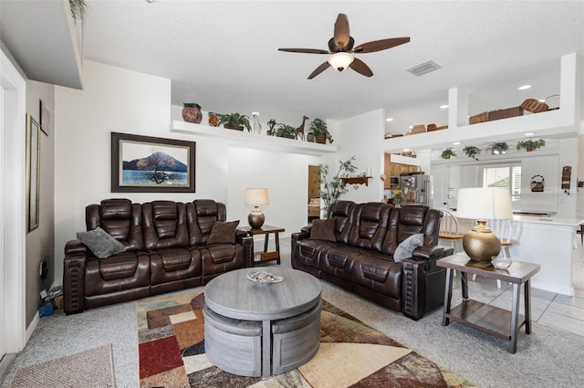 living room featuring ceiling fan and a textured ceiling