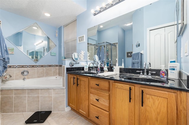 bathroom featuring independent shower and bath, vanity, a textured ceiling, and tile patterned floors