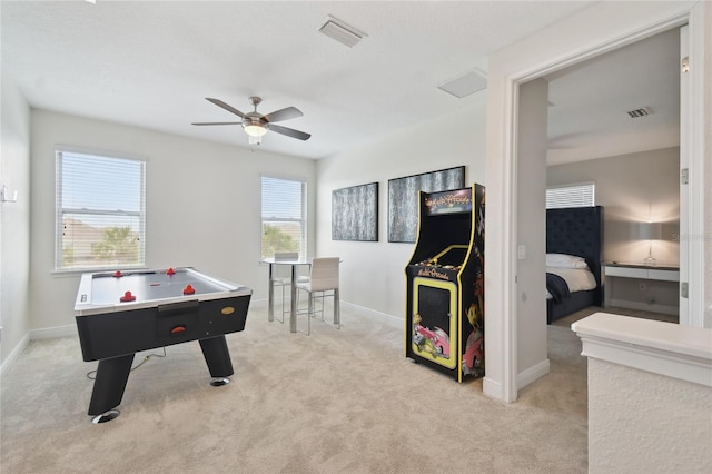 recreation room featuring ceiling fan, light colored carpet, and plenty of natural light