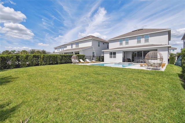 rear view of house featuring a patio, a yard, and a fenced in pool