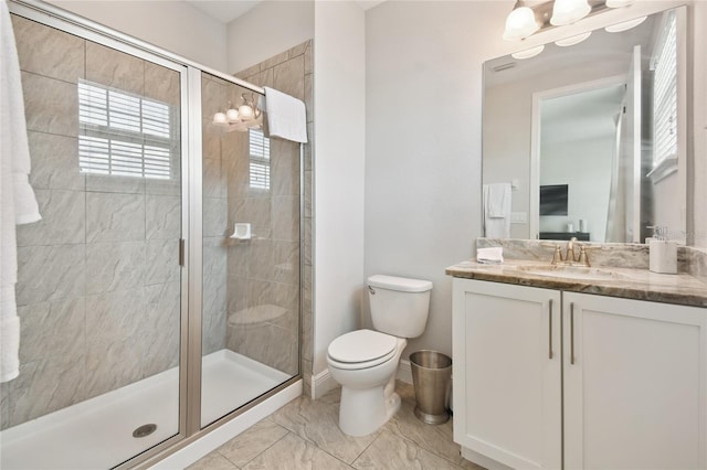 bathroom featuring vanity, toilet, and a shower with door