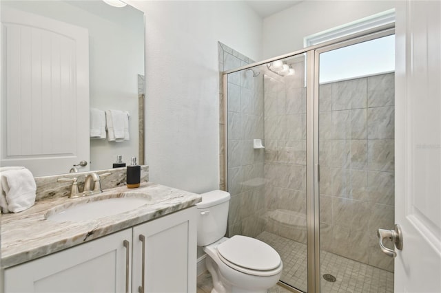 bathroom featuring an enclosed shower, vanity, and toilet