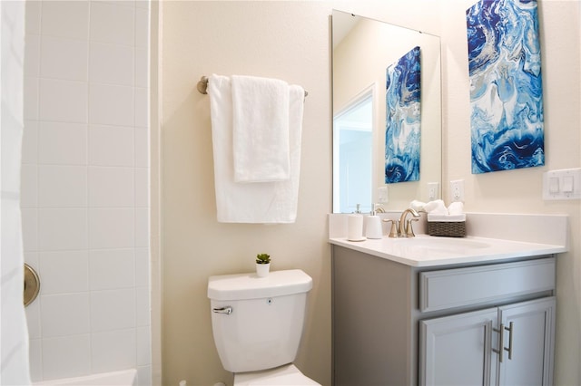 bathroom with a tile shower, vanity, and toilet