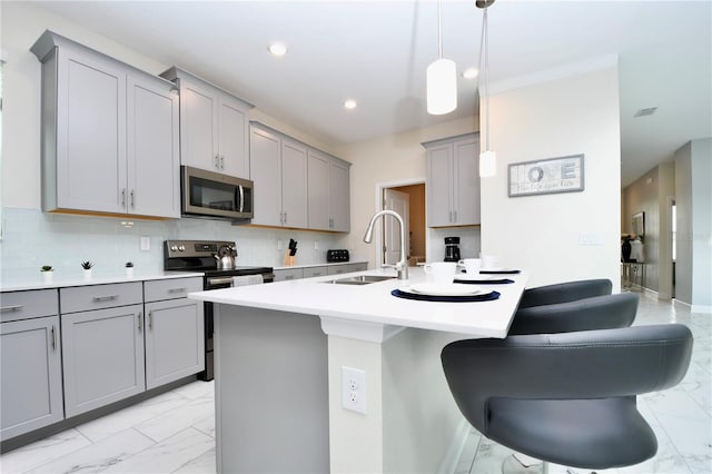 kitchen featuring gray cabinets, appliances with stainless steel finishes, pendant lighting, and sink