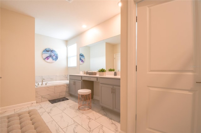 bathroom featuring tiled bath and vanity