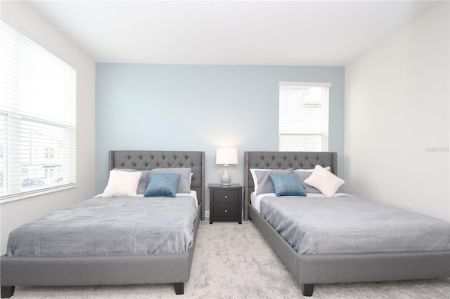 bedroom with multiple windows and light colored carpet