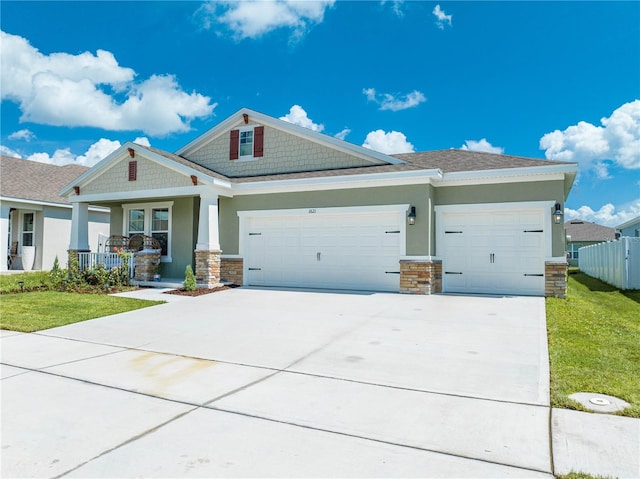 view of front of property with a front lawn, covered porch, and a garage