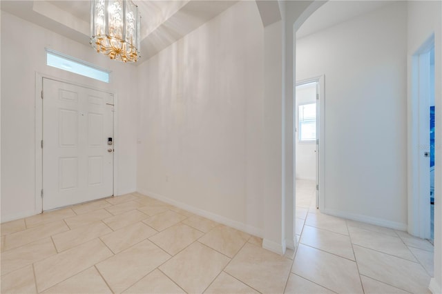 entryway featuring light tile patterned floors and a notable chandelier