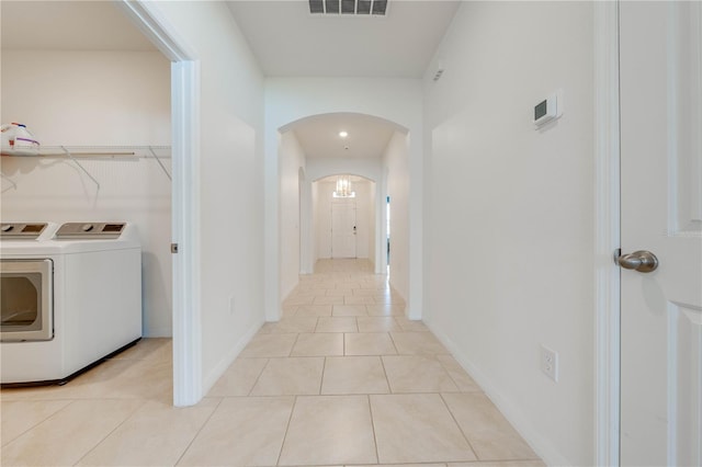 hallway featuring washing machine and clothes dryer and light tile patterned floors