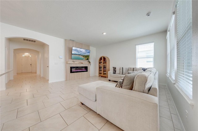 living room featuring a textured ceiling and light tile patterned floors