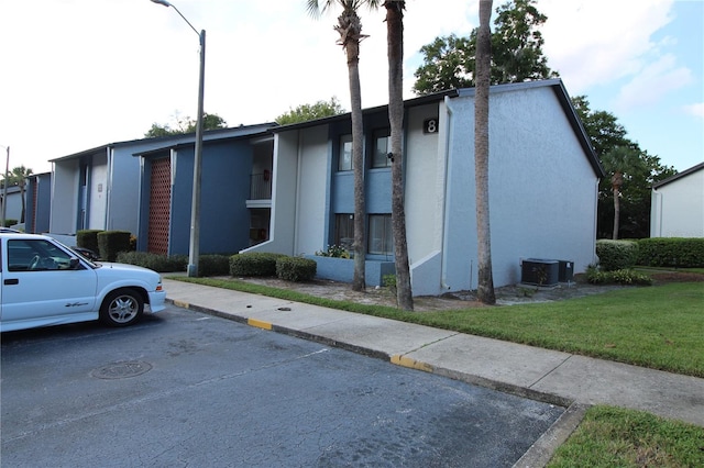 view of front of home with central AC and a front yard