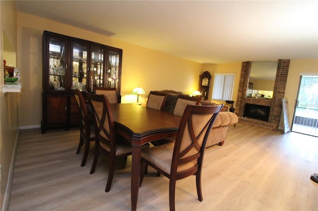 dining area with a brick fireplace and hardwood / wood-style floors