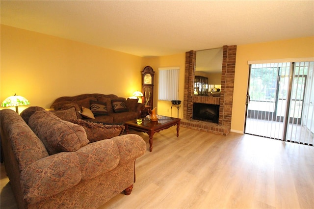 living room featuring a textured ceiling, a fireplace, and light hardwood / wood-style flooring