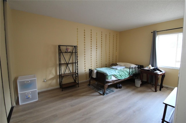 bedroom with hardwood / wood-style flooring and a textured ceiling