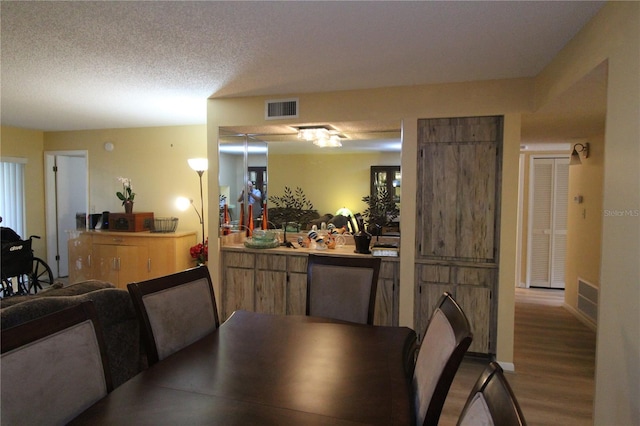 dining area featuring a textured ceiling and light wood-type flooring