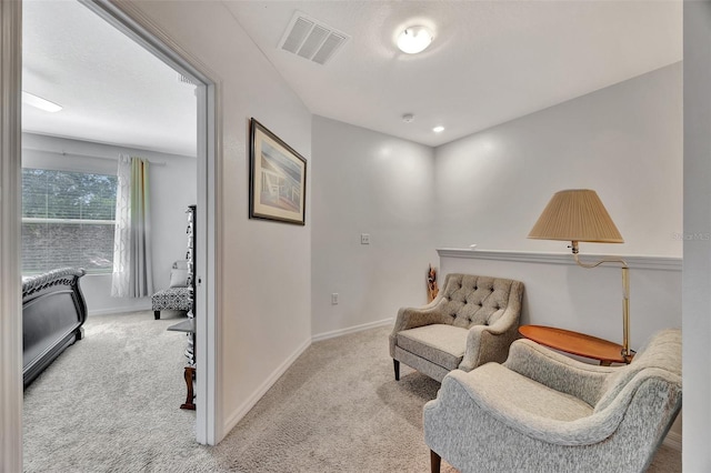 sitting room featuring light colored carpet