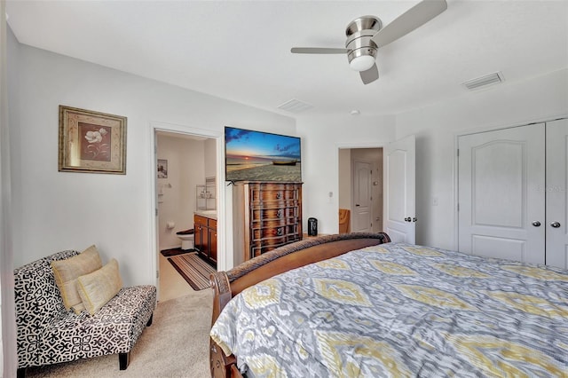 bedroom with a closet, ceiling fan, light colored carpet, and ensuite bathroom