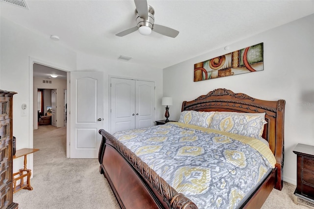 bedroom featuring light carpet, ceiling fan, and a closet