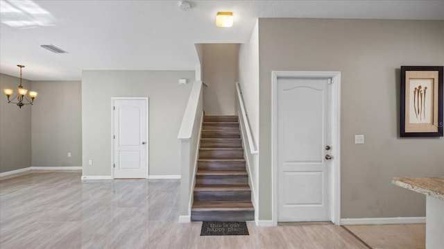 stairs featuring a chandelier