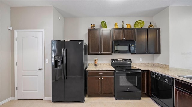 kitchen featuring light tile patterned floors, sink, dark brown cabinets, and black appliances