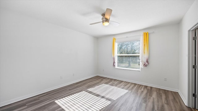 spare room with dark hardwood / wood-style flooring and ceiling fan