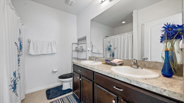 bathroom featuring toilet, vanity, and tile patterned flooring