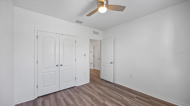 unfurnished bedroom with light hardwood / wood-style floors, a closet, and ceiling fan