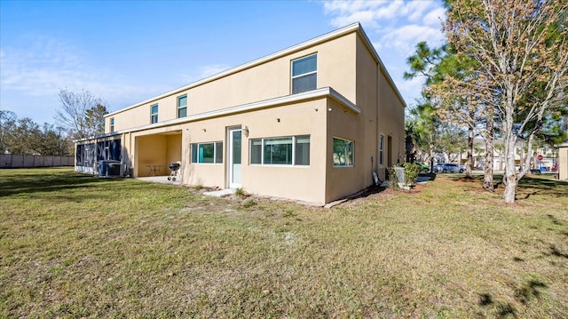 rear view of property featuring central AC and a lawn