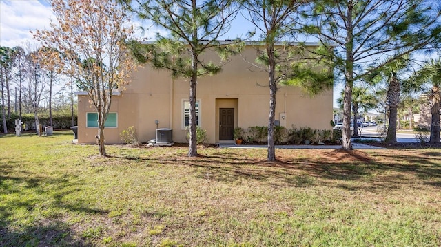 view of front facade featuring a front lawn and central air condition unit