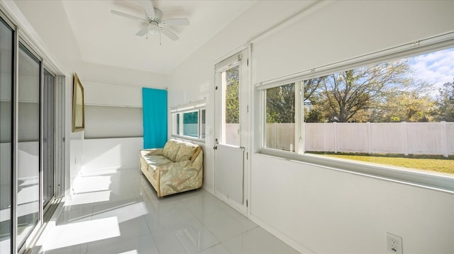 unfurnished sunroom with ceiling fan