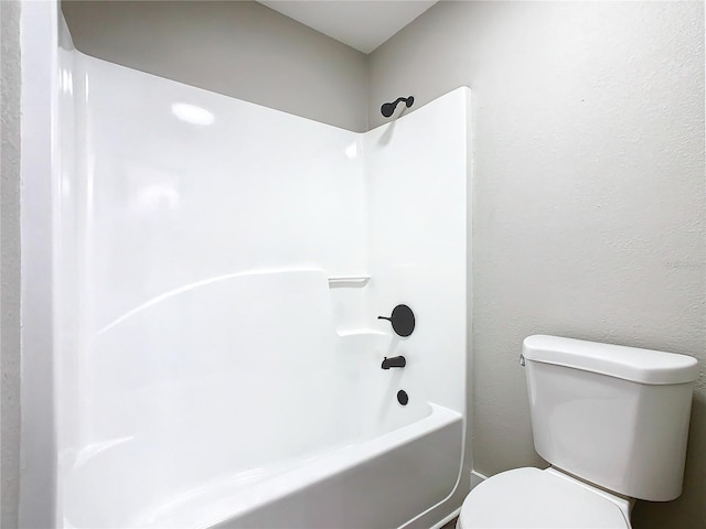 bathroom with bathing tub / shower combination and toilet