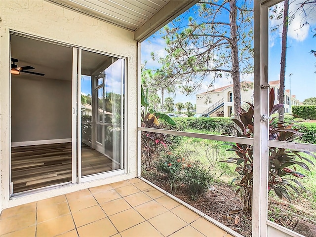 unfurnished sunroom with ceiling fan