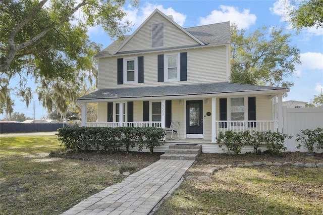 farmhouse inspired home with a front lawn and covered porch