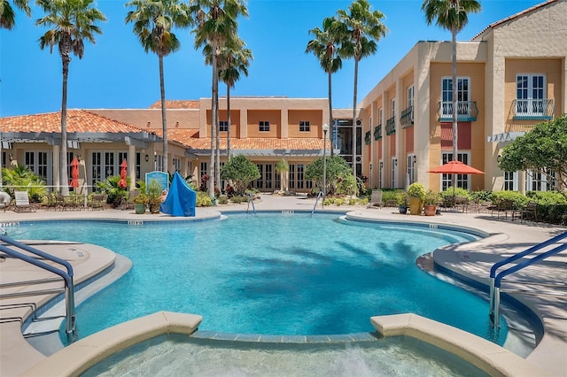 view of pool featuring a patio area and a hot tub