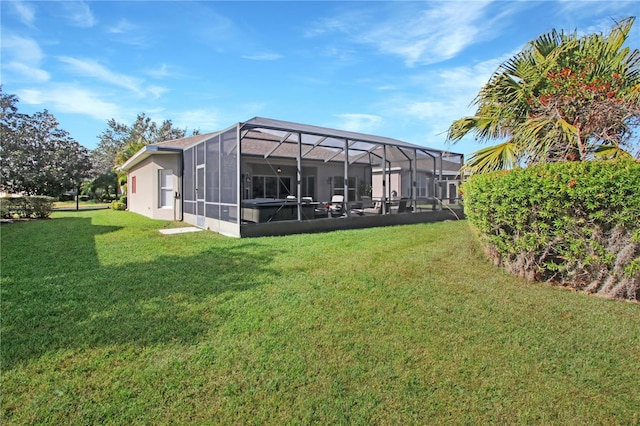 rear view of property with glass enclosure and a yard