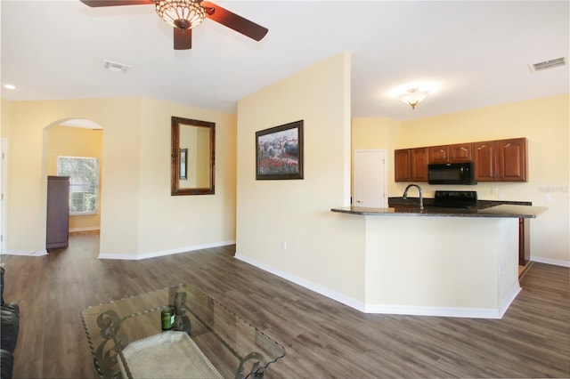 kitchen featuring kitchen peninsula, dark hardwood / wood-style flooring, and black appliances