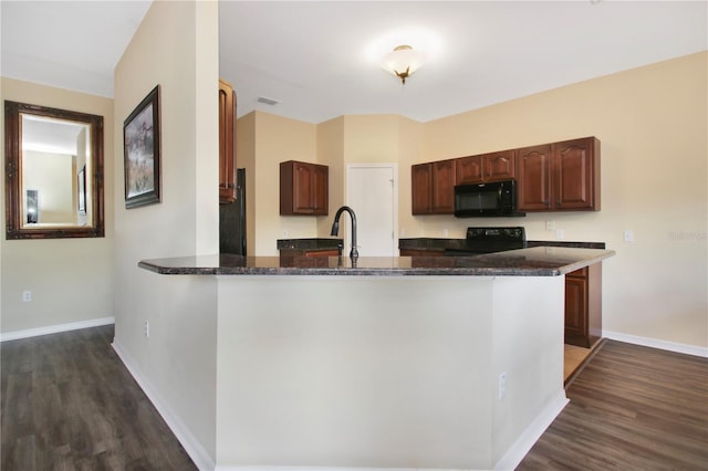 kitchen featuring kitchen peninsula, dark wood-type flooring, and black appliances