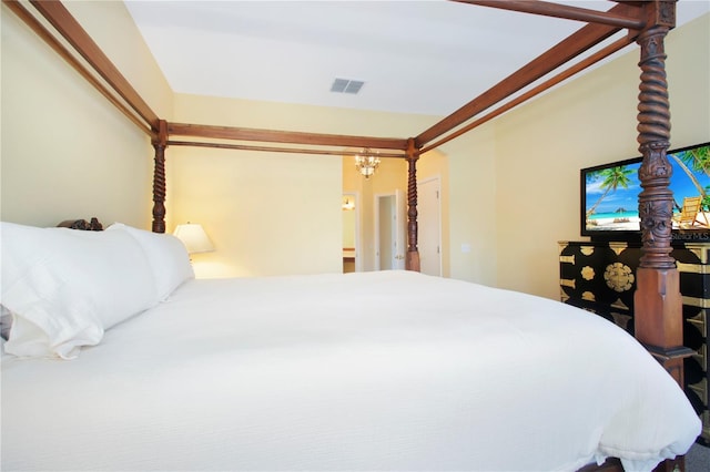 bedroom with ensuite bathroom and a notable chandelier