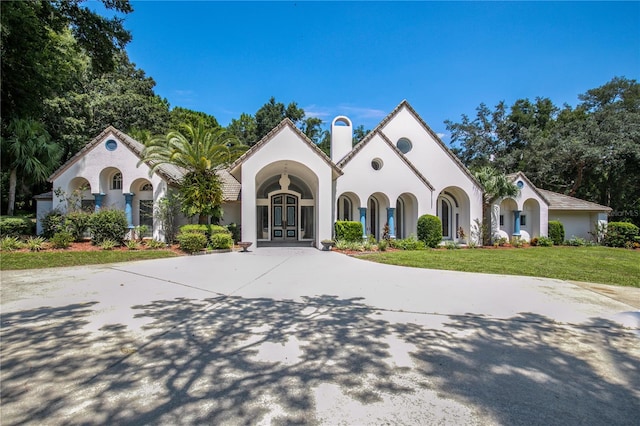 mediterranean / spanish-style house with a front yard