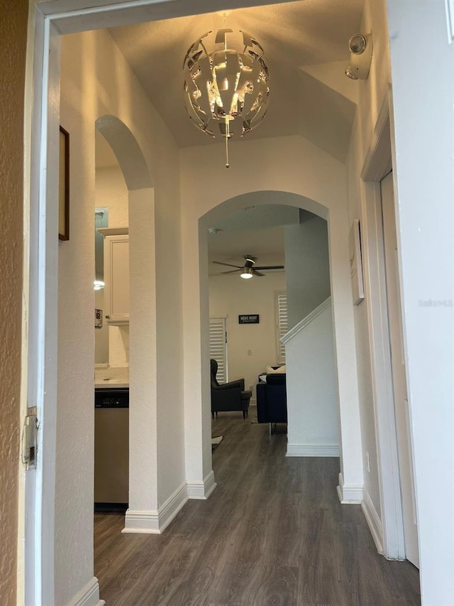 corridor featuring dark wood-type flooring and a chandelier