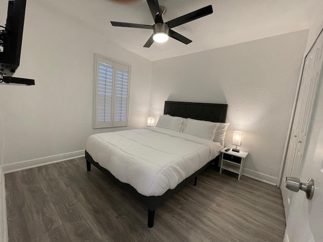 bedroom featuring dark hardwood / wood-style floors, ceiling fan, and a closet