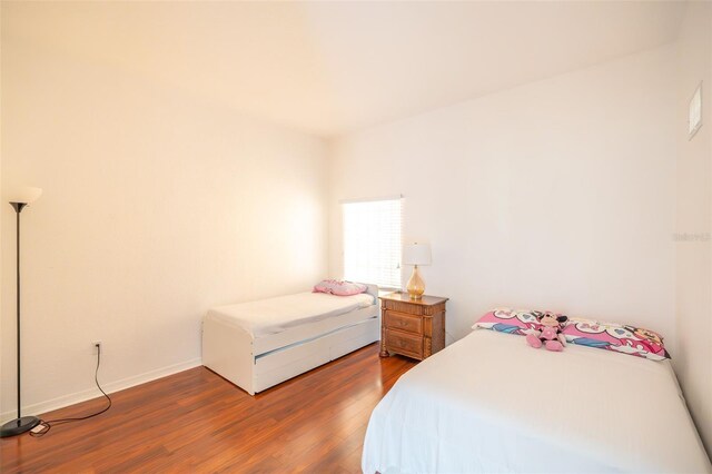 bedroom with dark wood-type flooring