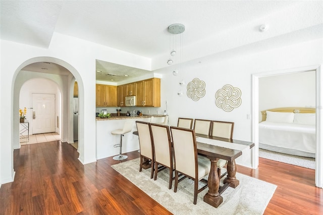 dining area with a textured ceiling and dark wood-type flooring