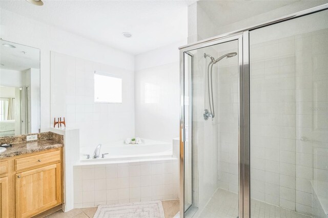 bathroom featuring tile patterned floors, independent shower and bath, and vanity