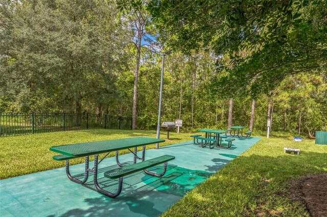 view of property's community with a lawn and a patio