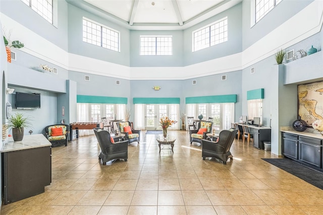 living room with a high ceiling and light tile patterned floors