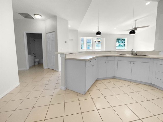 kitchen with pendant lighting, light tile patterned flooring, sink, kitchen peninsula, and ceiling fan