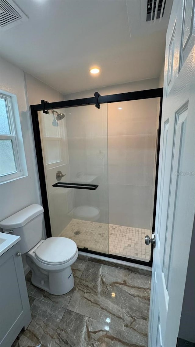 bathroom featuring vanity, toilet, and walk in shower